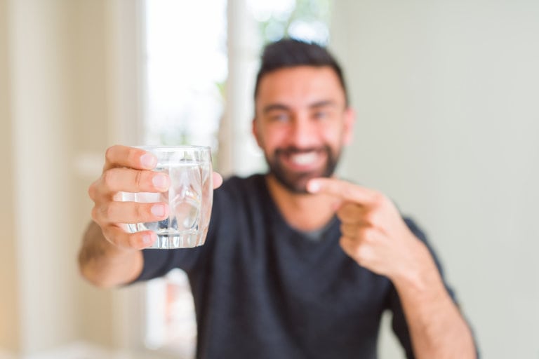 man pointing to glass of water