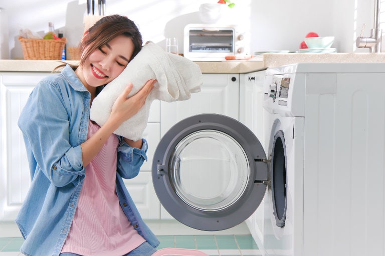 woman pulling soft clothes from dryer